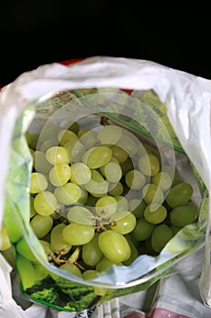 Inside a blurred grocery bag - fresh green grapes