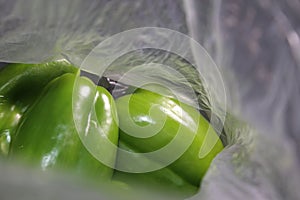 Inside a blurred grocery bag - fresh green peppers
