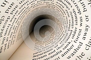 Inside the book concept. Latin letters and words on an tunnel shaped, perspective book page with black dramatic light. Education,