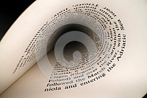 Inside the book concept. Latin letters and words on an tunnel shaped, perspective book page with black dramatic light. Education,