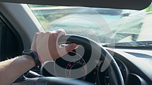 Inside a Car. A Man`s Hands on the Steering Wheel