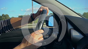 Inside a Car. A Man`s Hands on the Steering Wheel