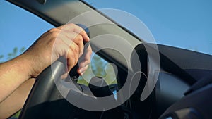 Inside a Car. A Man`s Hands on the Steering Wheel