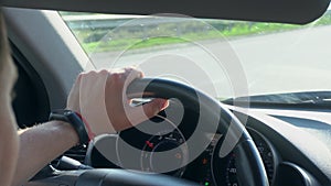 Inside a Car. A Man`s Hands on the Steering Wheel