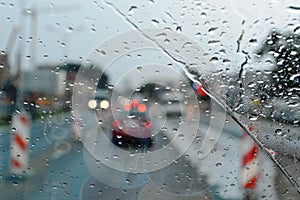 Inside car when rainning, Road view wtih restriction signs through car window with rain drops. Drizzle on the windshield
