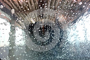 Inside a car wash machine, water flows over the window