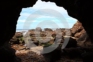 Inside the cavern of Caves Beach, rocky landscape by low tide