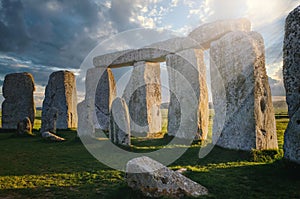 Inside the circle of stones at Stonehenge with the morning sun casting rays through the rock