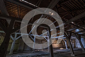 Inside dark abandoned ruined wooden decaying hangar with rotting columns