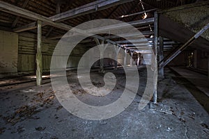Inside dark abandoned ruined wooden decaying hangar with rotting columns