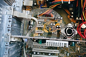 Inside details of the old personal computer. Cooler, motherboard, wires and video card in the dust. Broken PC