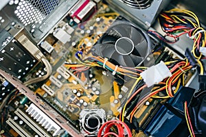 Inside details of the old personal computer. Cooler, motherboard, wires and video card in the dust. Broken PC