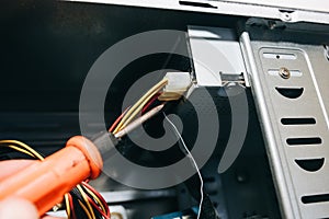 Inside details of the old personal computer. Motherboard, cable wires and video card in the dust. Man is repairing broken PC with