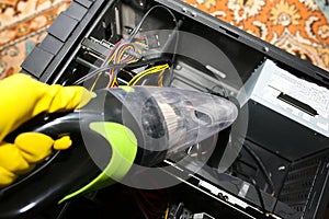 Inside details of the personal computer. Man is cleaning wires with vacuum cleaner. Small hoover. Motherboard and video card in