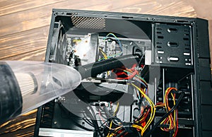 Inside details of the personal computer. Man is cleaning wires with vacuum cleaner. Small hoover. Motherboard and video card in