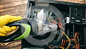 Inside details of the personal computer. Man is cleaning wires with vacuum cleaner. Small hoover. Motherboard and video card in
