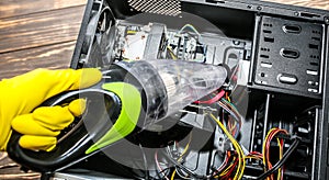 Inside details of the personal computer. Man is cleaning wires with vacuum cleaner. Small hoover. Motherboard and video card in