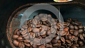 Inside electric coffee-mill. Slow motion view of roasted coffee beans being ground by coffee grinder at home. Close-up