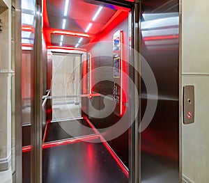 Inside an elevator lift cabin with red light reflection lines in the mirror. Look inside an elevator car.