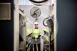 Inside a factory, industrial worker in action on machine.