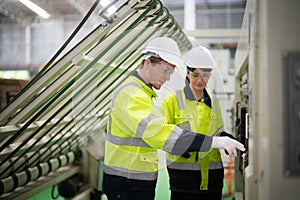 Inside a factory, industrial worker in action on machine.