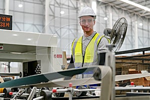 Inside a factory, industrial worker in action on machine.