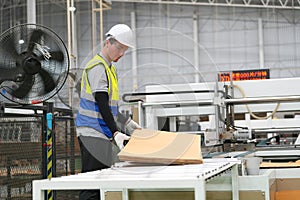 Inside a factory, industrial worker in action on machine.