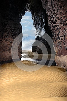 Inside golden sandy beach cliff cave