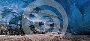 Inside of an ice cave with icicle hanging from an ice cave ceiling