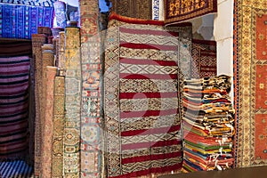 Inside interior of Carpet shop with colourful moroccan rugs and berber carpets on display in a souk market in the centre of medina