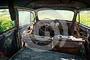 Inside interior of Old retro rusty abandoned car overgrown with grass, close up