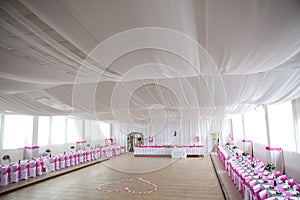 The inside of a massive white wedding tent with ta