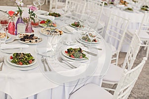 The inside of a massive white wedding tent with tables and chairs already in position.