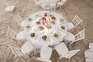 The inside of a massive white wedding tent with tables and chairs already in position.