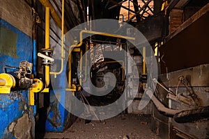 Inside old collapsed industrial building. Old rusty pipeline