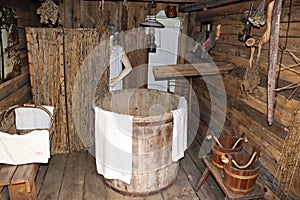 Inside an old ethnographic bathhouse with a large wooden bathing tub