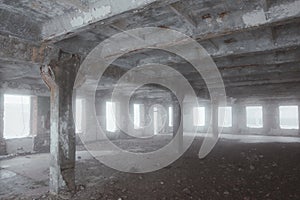 Inside old ruined abandoned industrial building in the fog