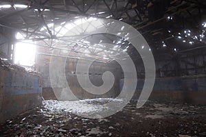 Inside old ruined abandoned industrial building in the fog