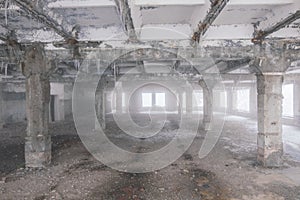 Inside old ruined abandoned industrial building in the fog