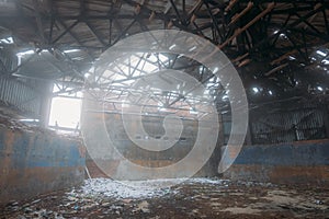 Inside old ruined abandoned industrial building in the fog