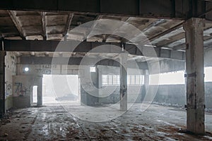 Inside old ruined abandoned industrial building in the fog