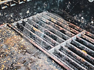 inside of an old rusty barbecue with mold on the grill grate