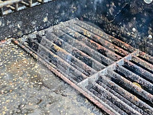 inside of an old rusty barbecue with mold on the grill grate