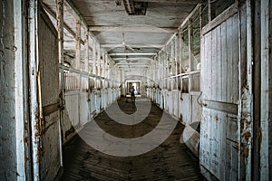 Inside old wooden stable or barn with horse boxes, tunnel or corridor view