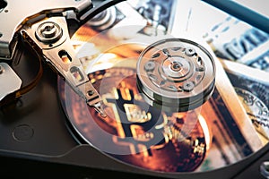 Open computer hard drive with the projected bitcoin symbol