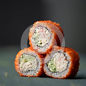 Inside-out Sushi Set. Pyramid of three sushi. Rolls in masago or tobiko caviar on gray blurred background. Healthy