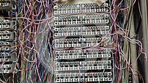 Inside a PABX telephone booth that has a number of connecting cables in many colors in the analog