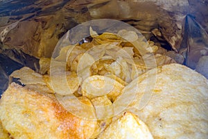 Inside the potato chips bag. Opened pack of original taste delicious potato crisps. Fast food and unhealthy eating concept