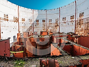 Inside round ruined and abandoned nuclear rector room in Crimean destroyed NPP, rusty steel equipment of nuclear turbine generator