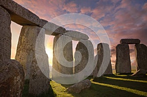 Inside the Stonehenge Circle of Stones with a Dramatic Sky Sunrise behind it